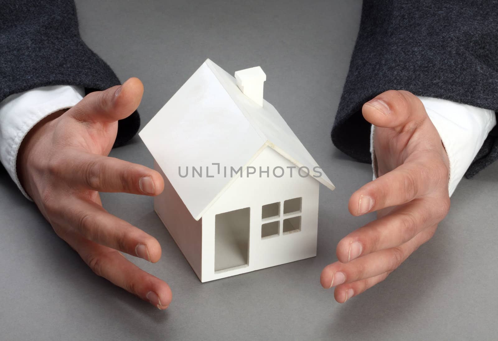 Hands and house model. Real property or insurance concept 