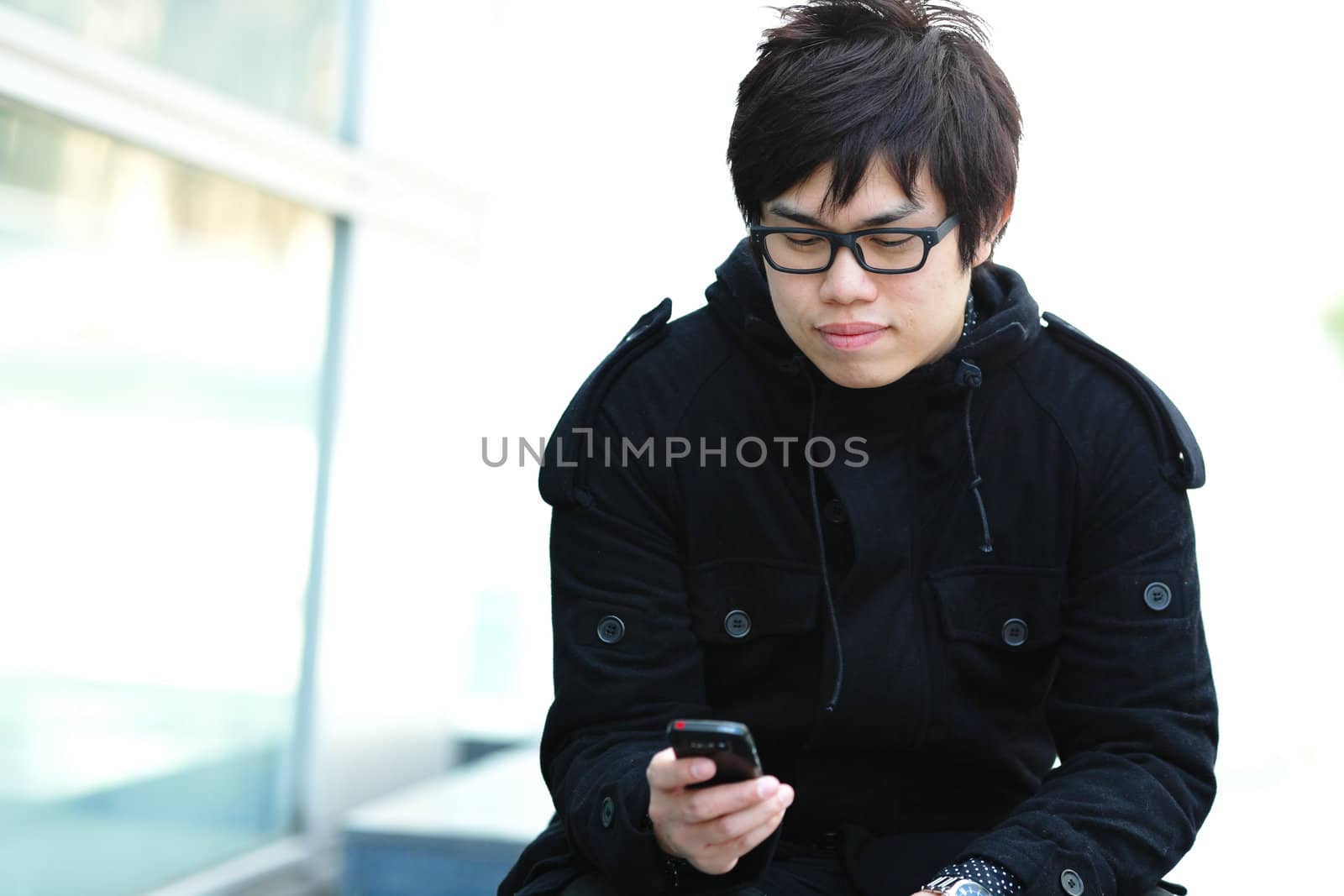 casual asian man sms on cell phone by leungchopan