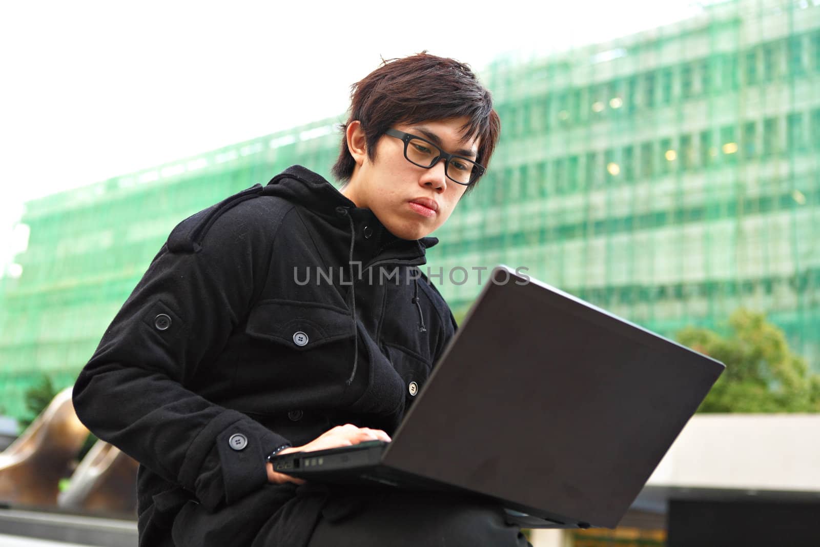 asian man using computer outdoor