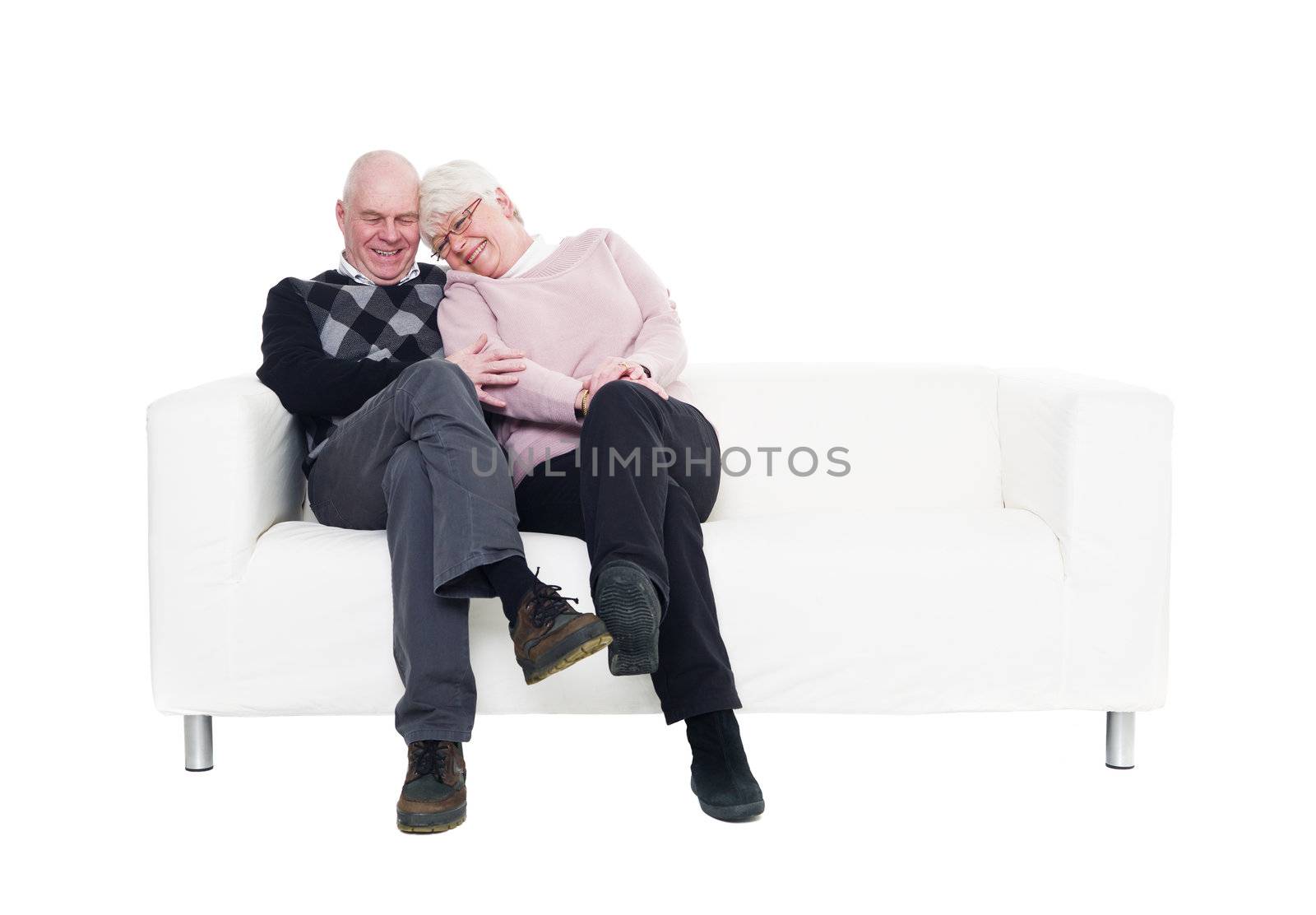 Older couple in a sofa isolated on white background
