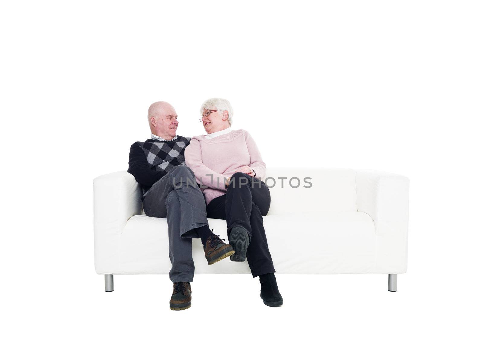 Older couple in a sofa isolated on white background