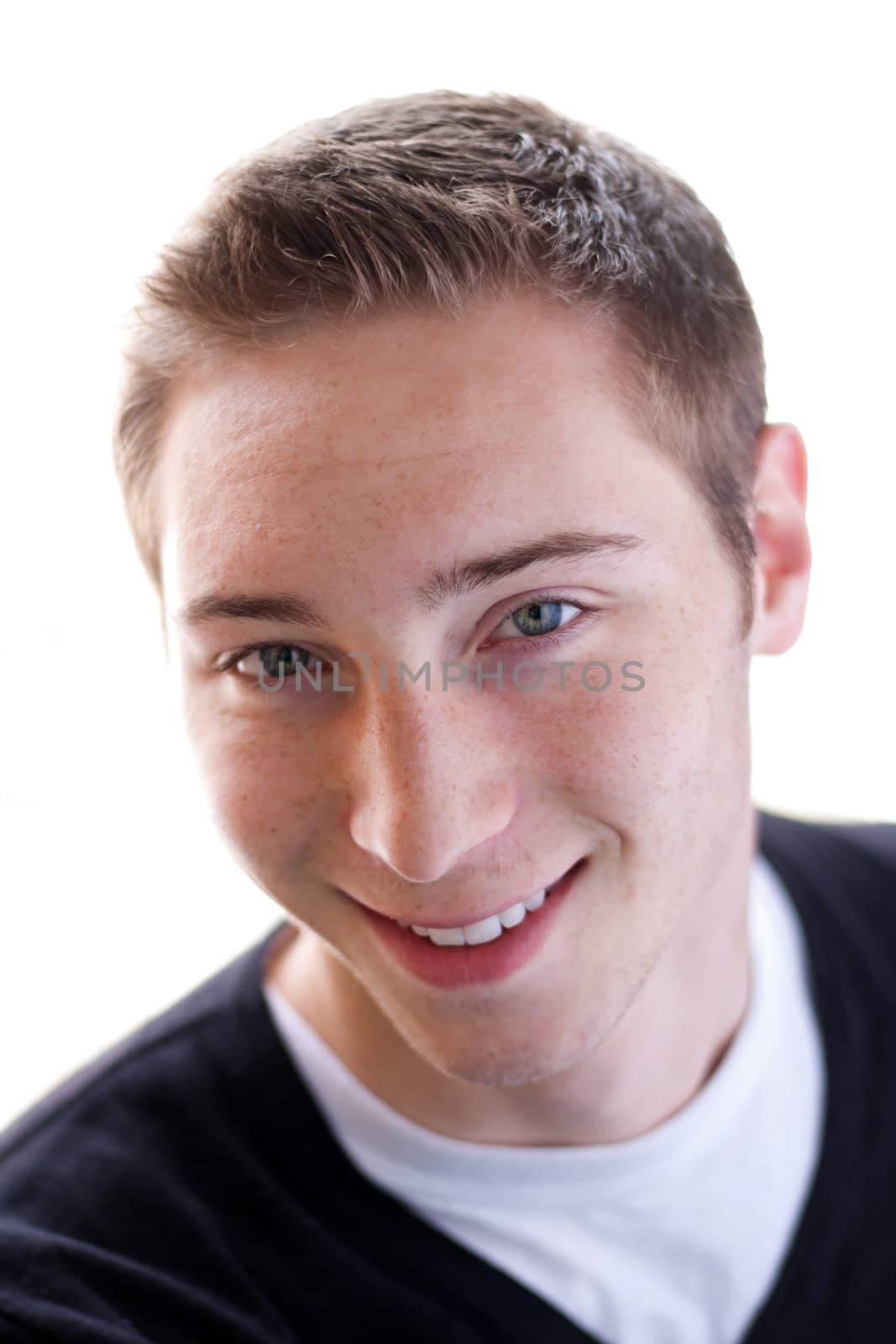 High key portrait of a smiling young man in his early twenties. Shallow depth of field.