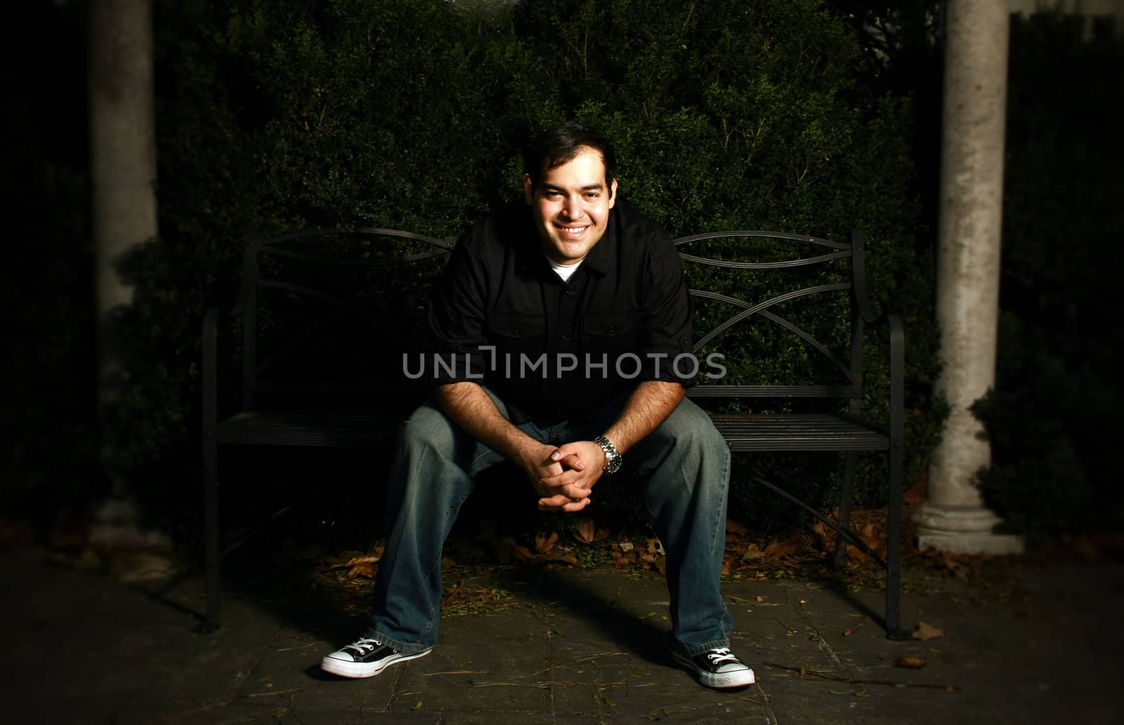 A smiling man sitting on a bench