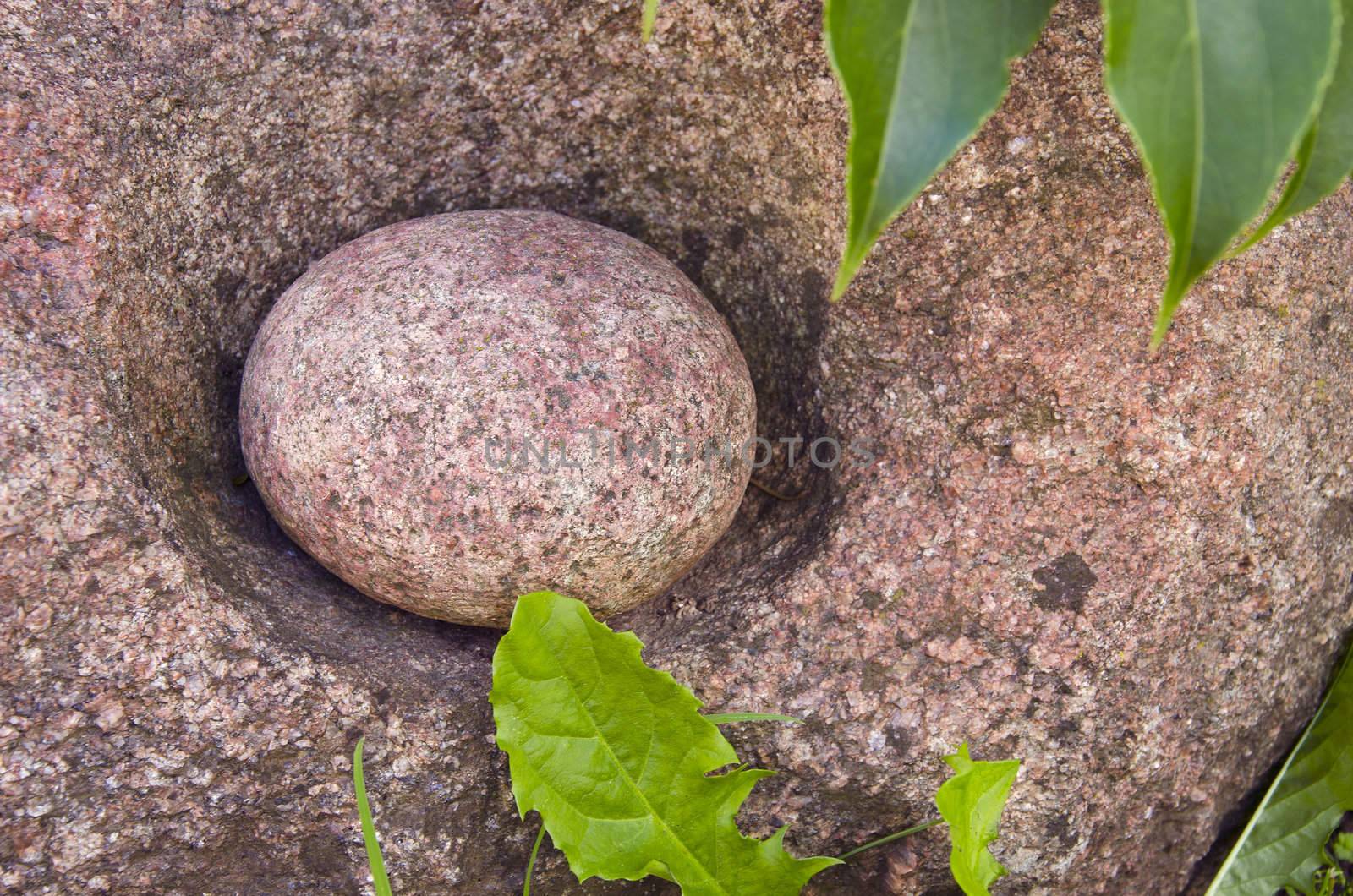 Small round stone in larger one. Old traditional tool for milling grain.