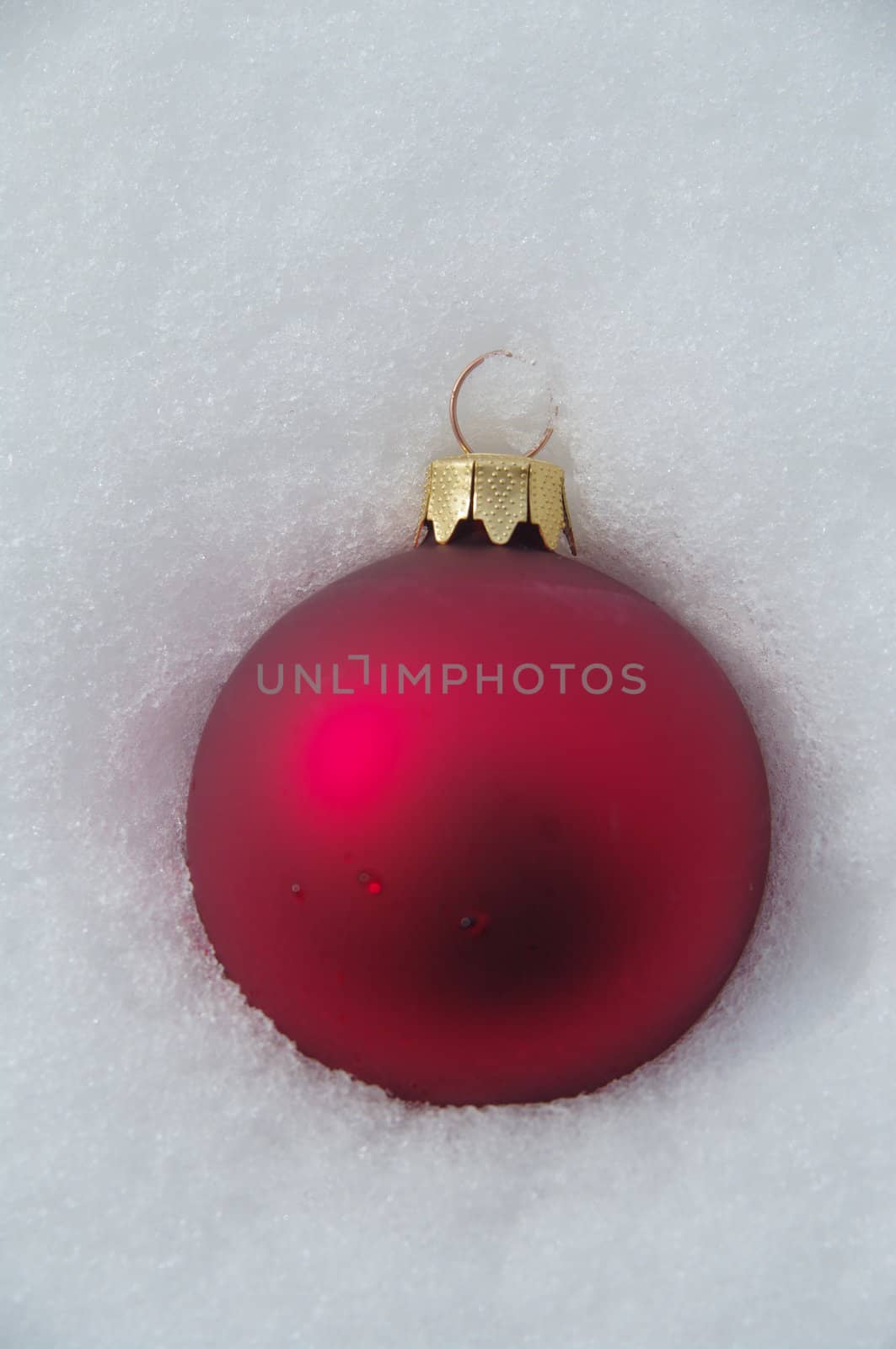 a red bauble in snowy lwinter andscape