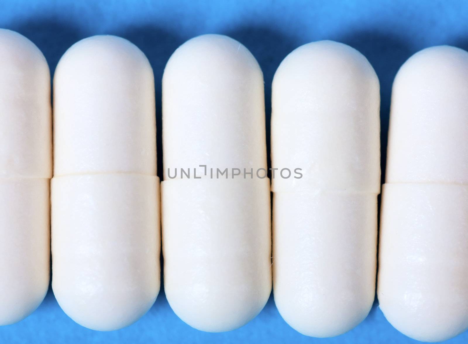 Macro view of white pills on a blue background