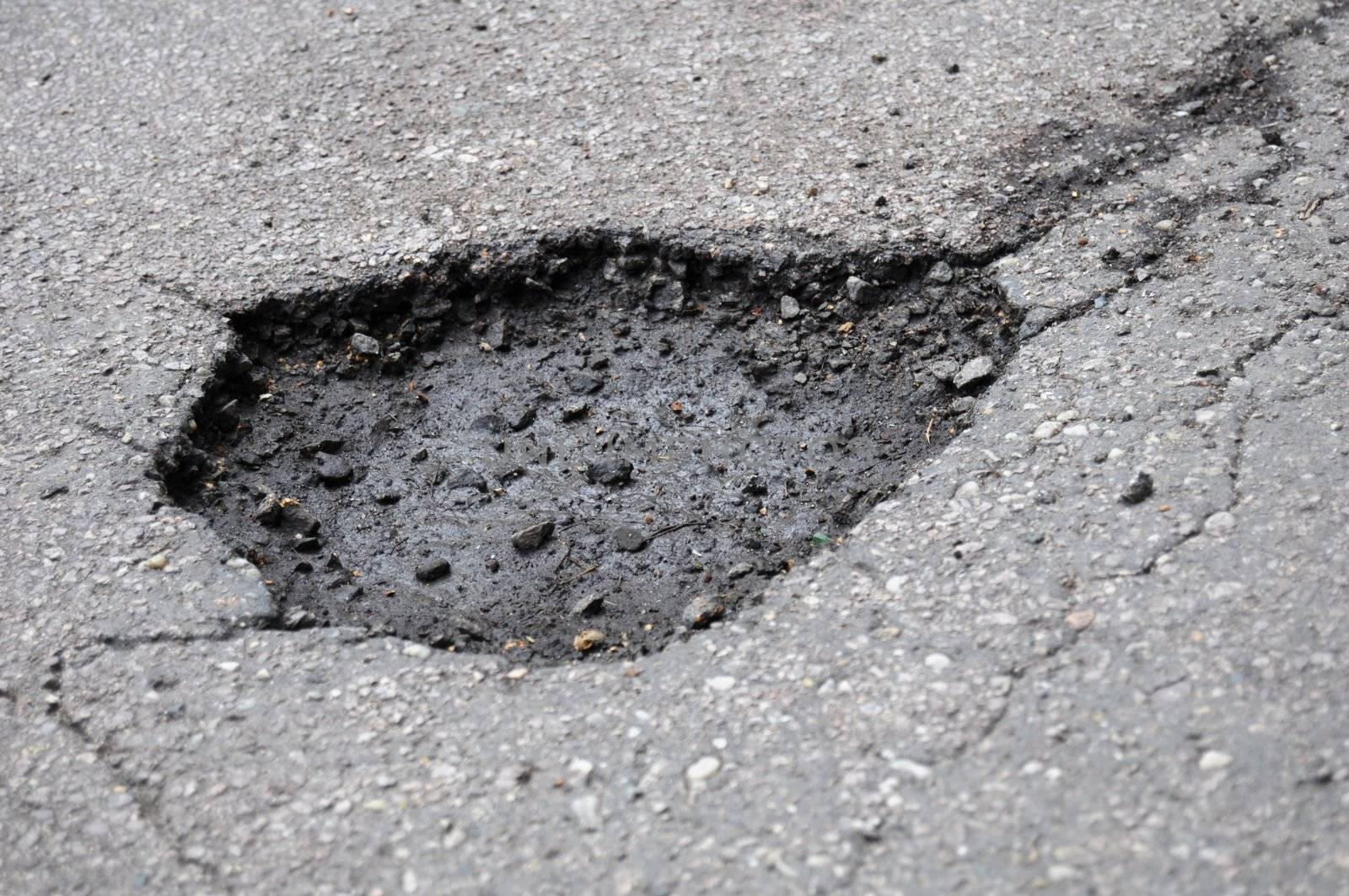 pothole road damage or pot hole concept with street