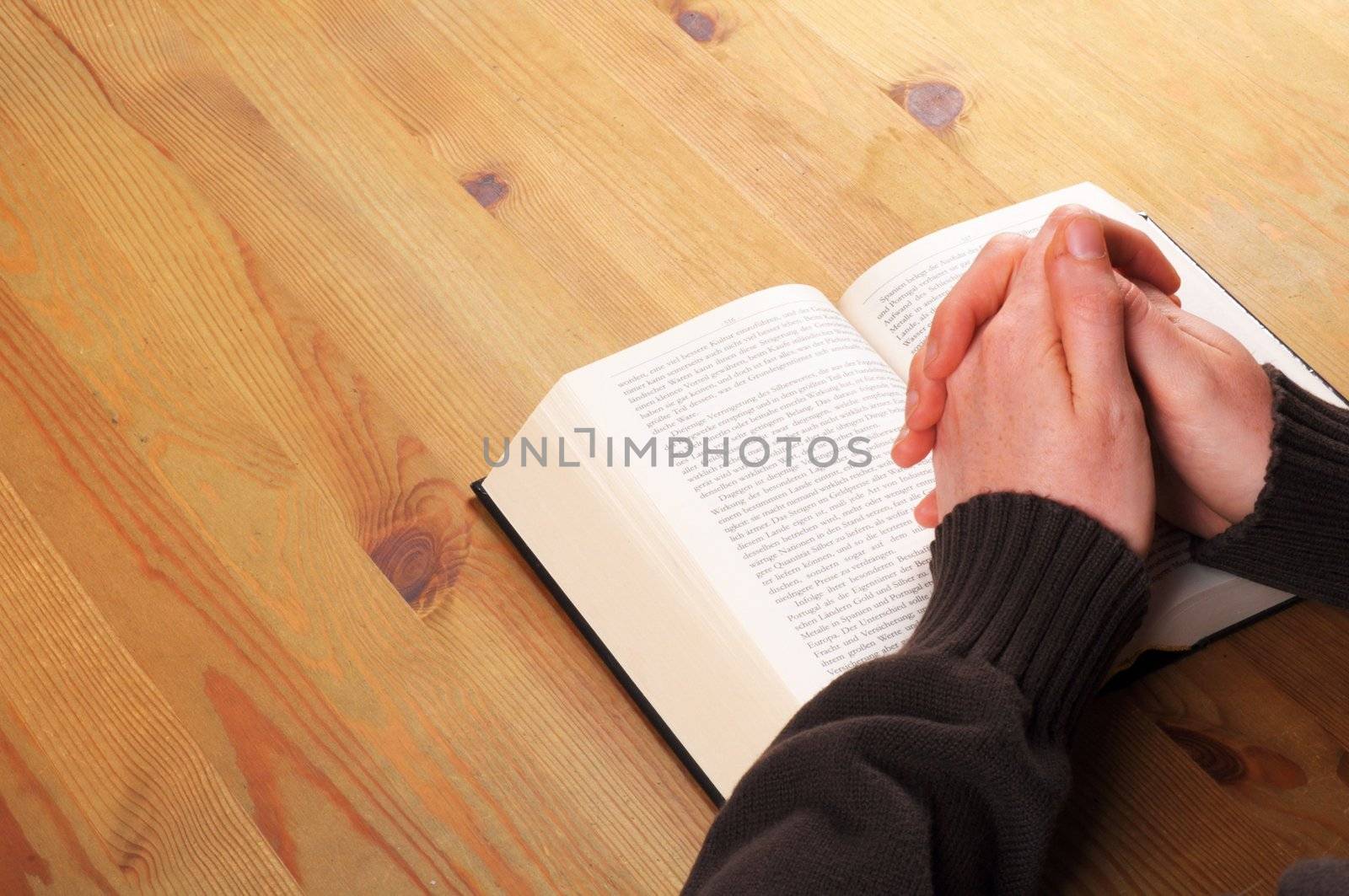 praying hands and book showing christian religion concept