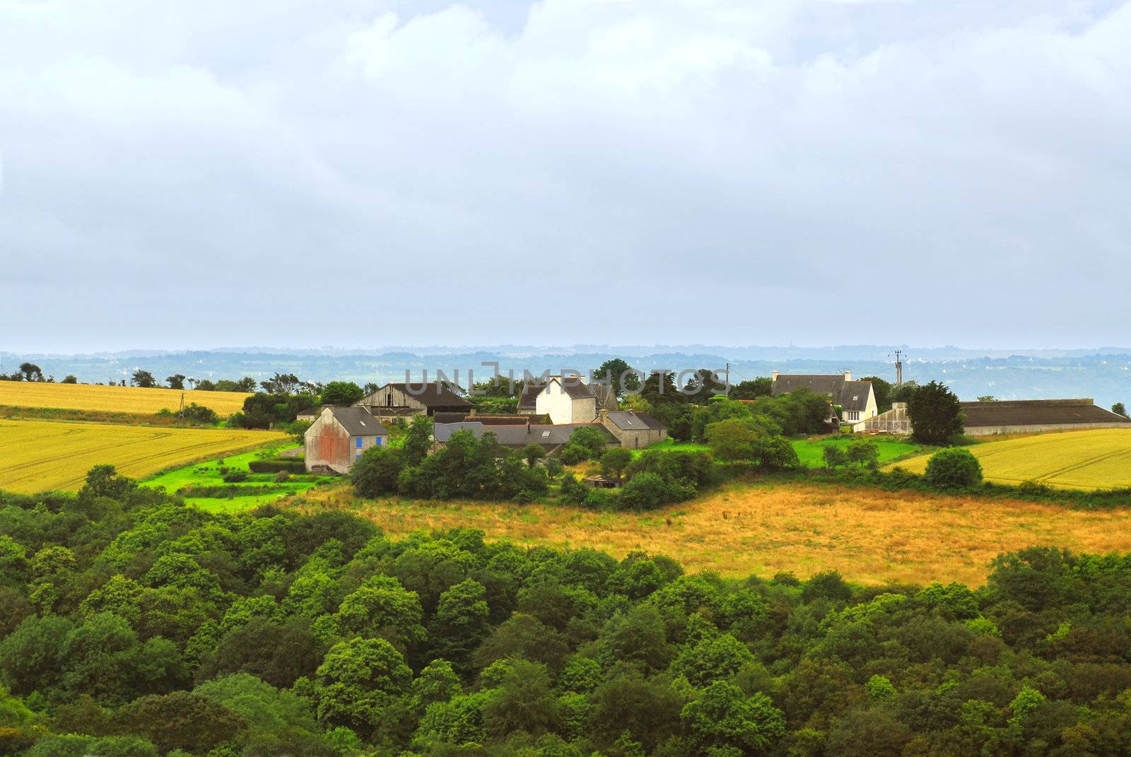 Scenic view on agricultural landscape with a farm house in rural Brittany, France