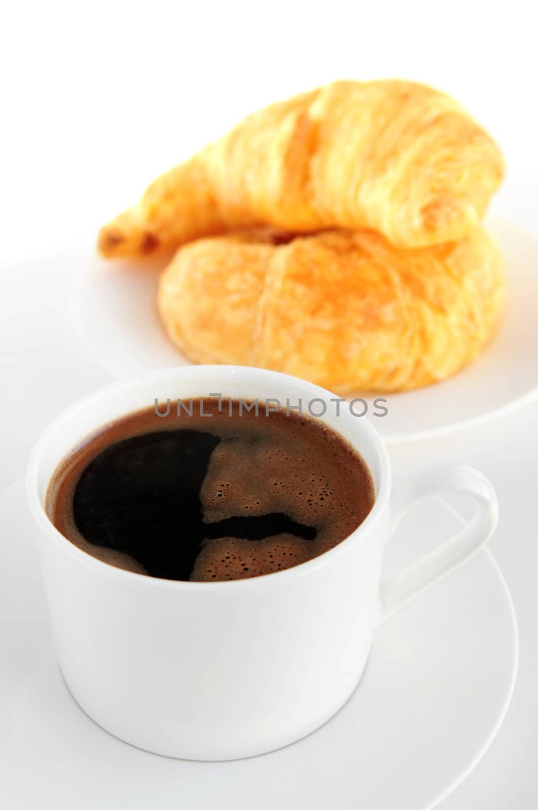 Breaksfast of black coffee and fresh croissants