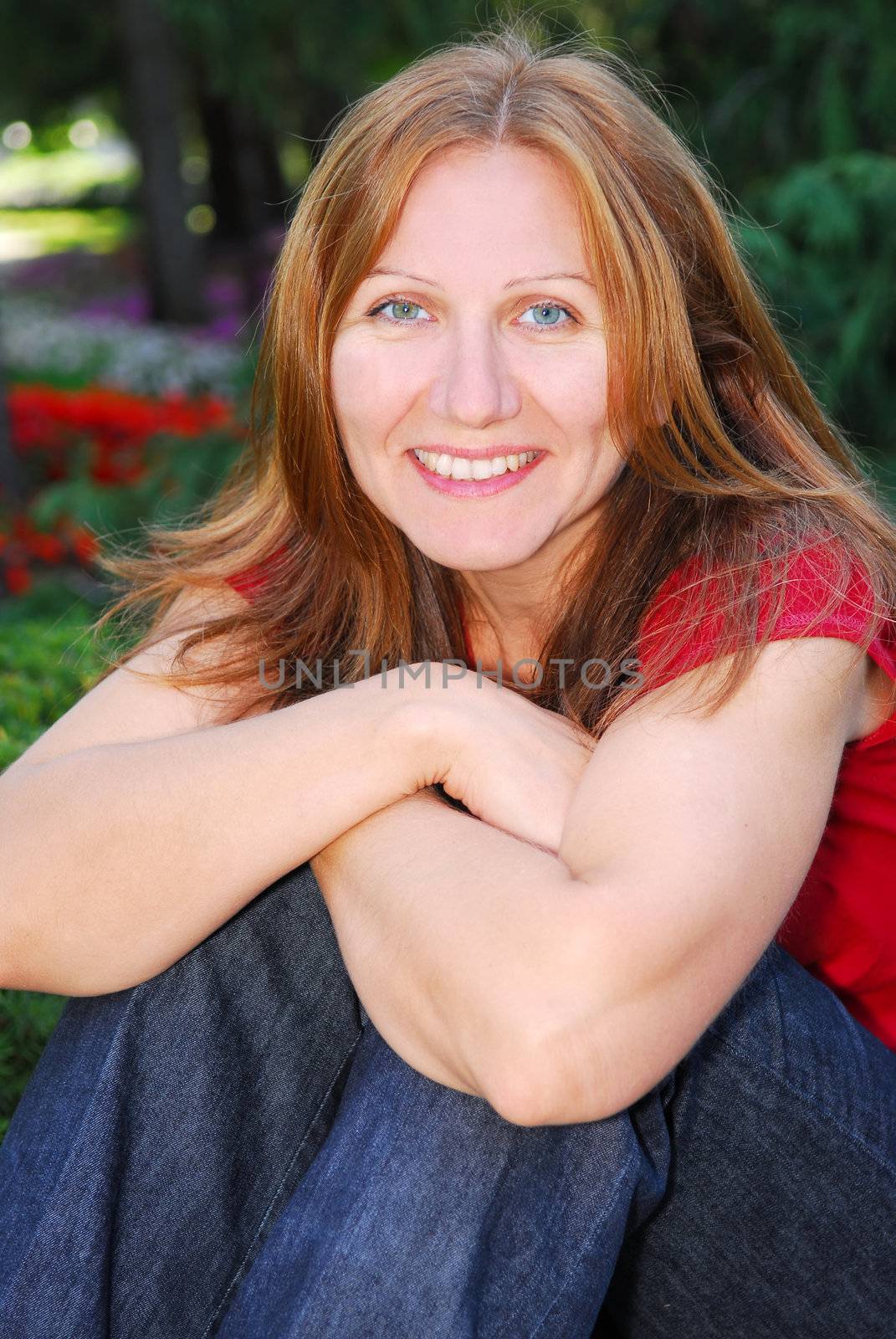 Portrait of smiling attractive mature woman relaxing in summer park