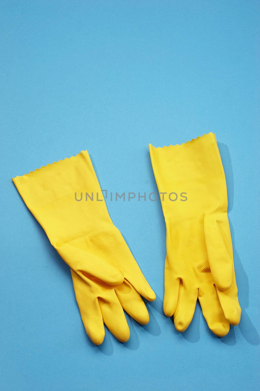 yellow rubber gloves on the blue background