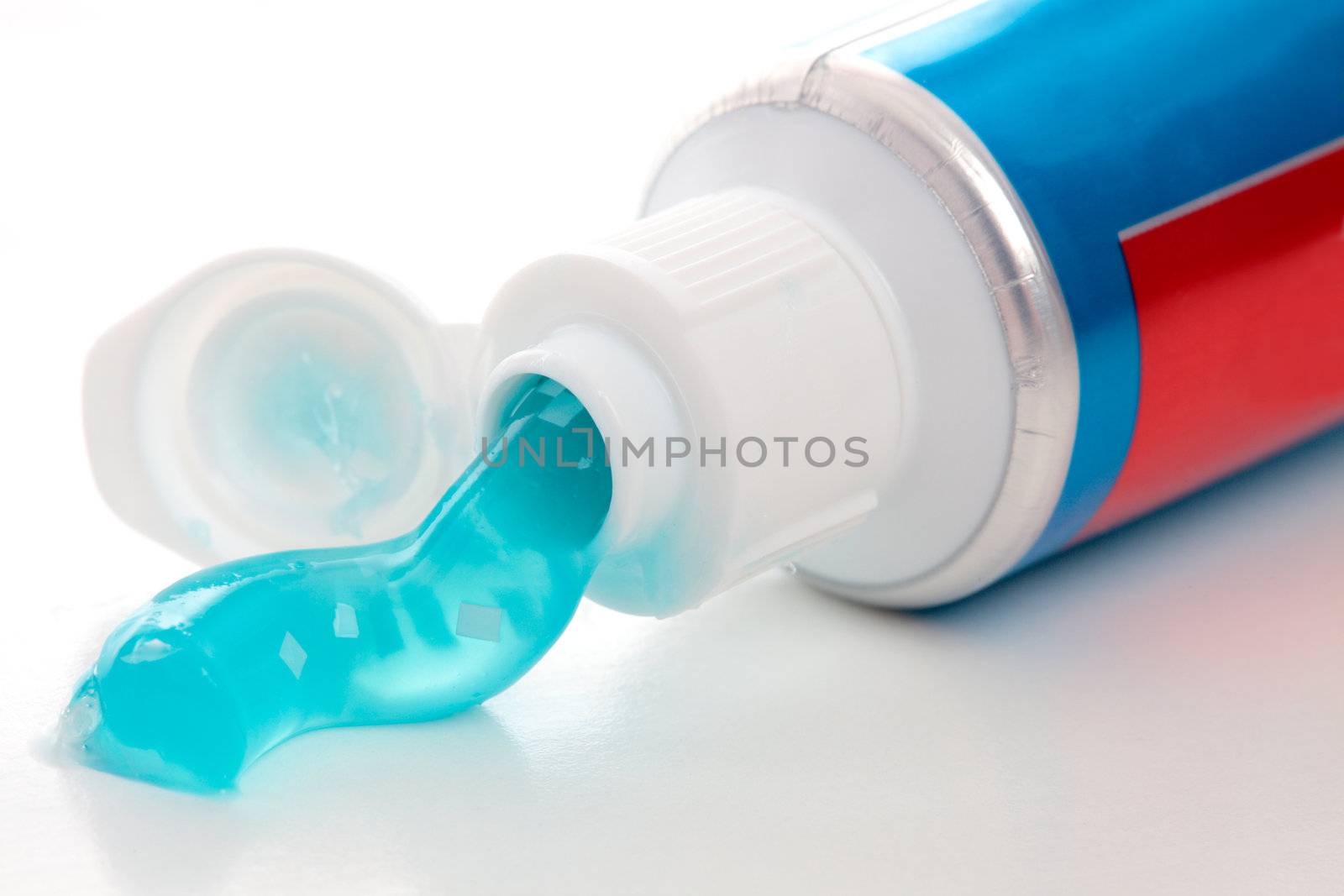 A tube of toothpaste with breath strips.  White background.  Closeup.