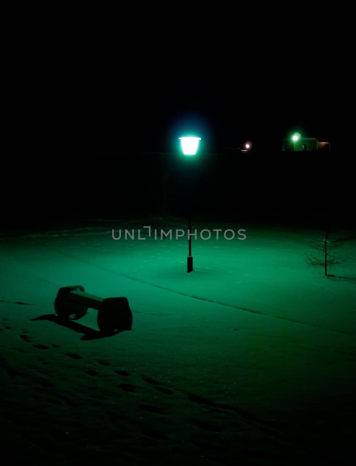 Light from lantern illuminates bench in the park.