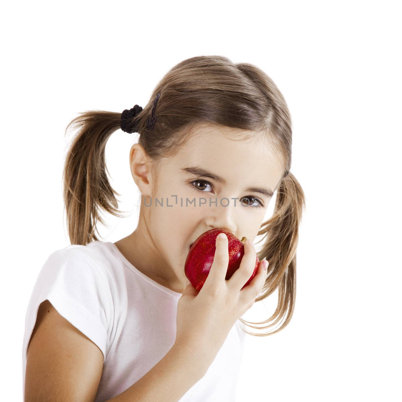 Portrait of a beautiful little girl eating a red apple