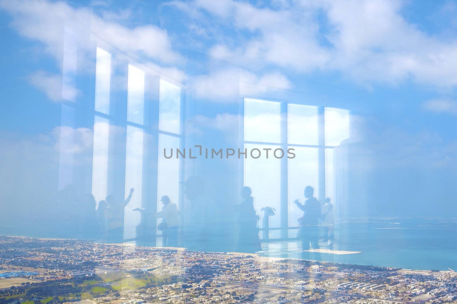 Reflection of people standing on an observation deck looking out on Dubai city