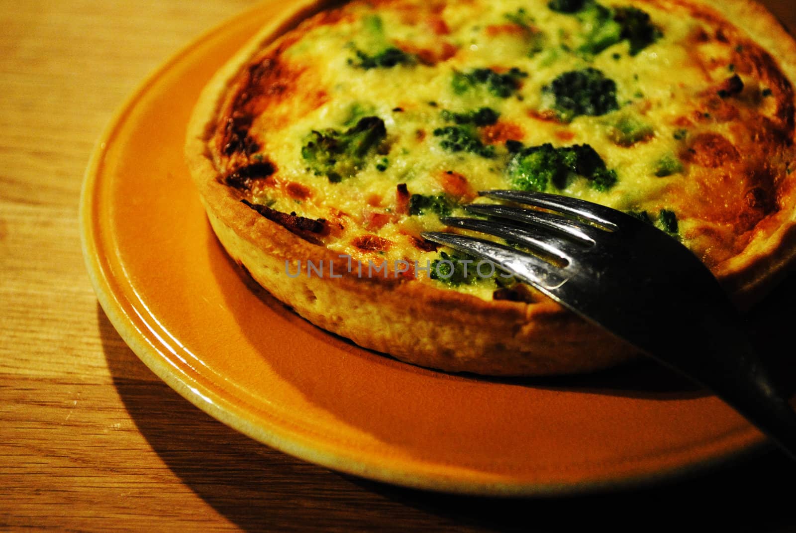 A quiche with for stuck in it.