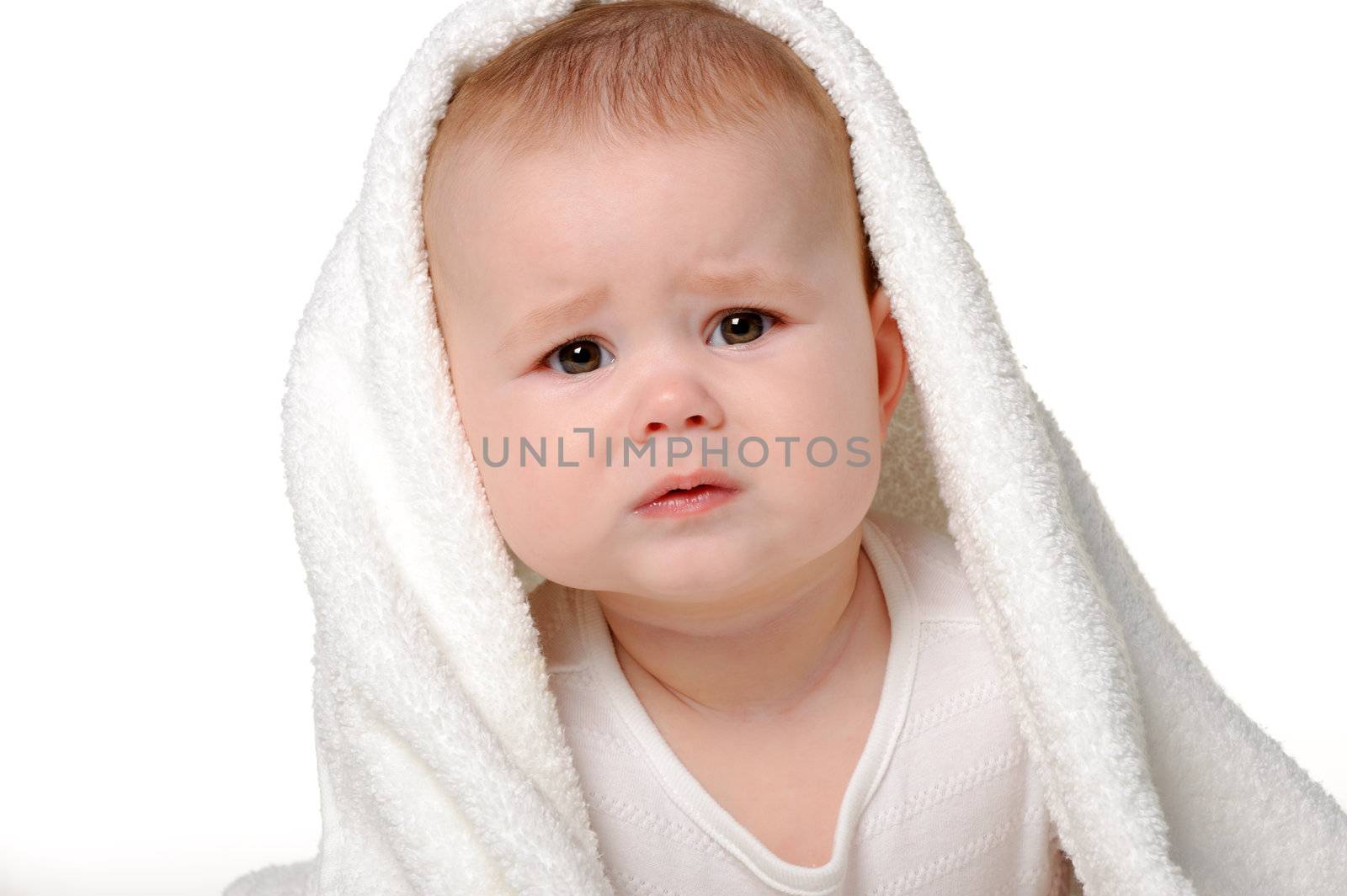 The crying baby under a towel. Age of 8 months. It is isolated on a white background