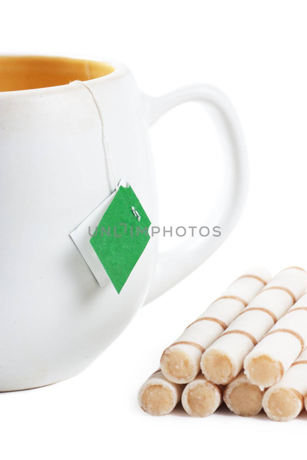 Closeup view of handle of cup and sweets over white background