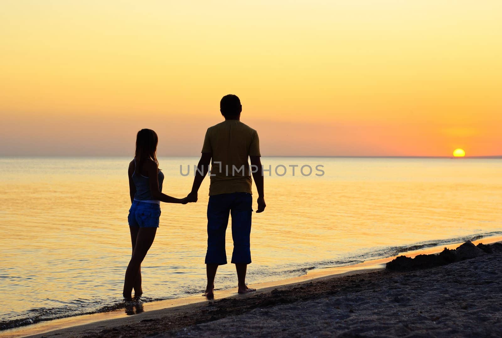 Couple silhouette on the beach at sunset 