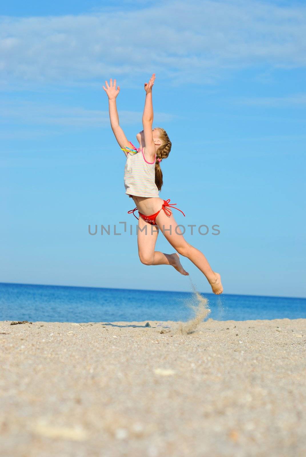 Jumping little girl on the beach