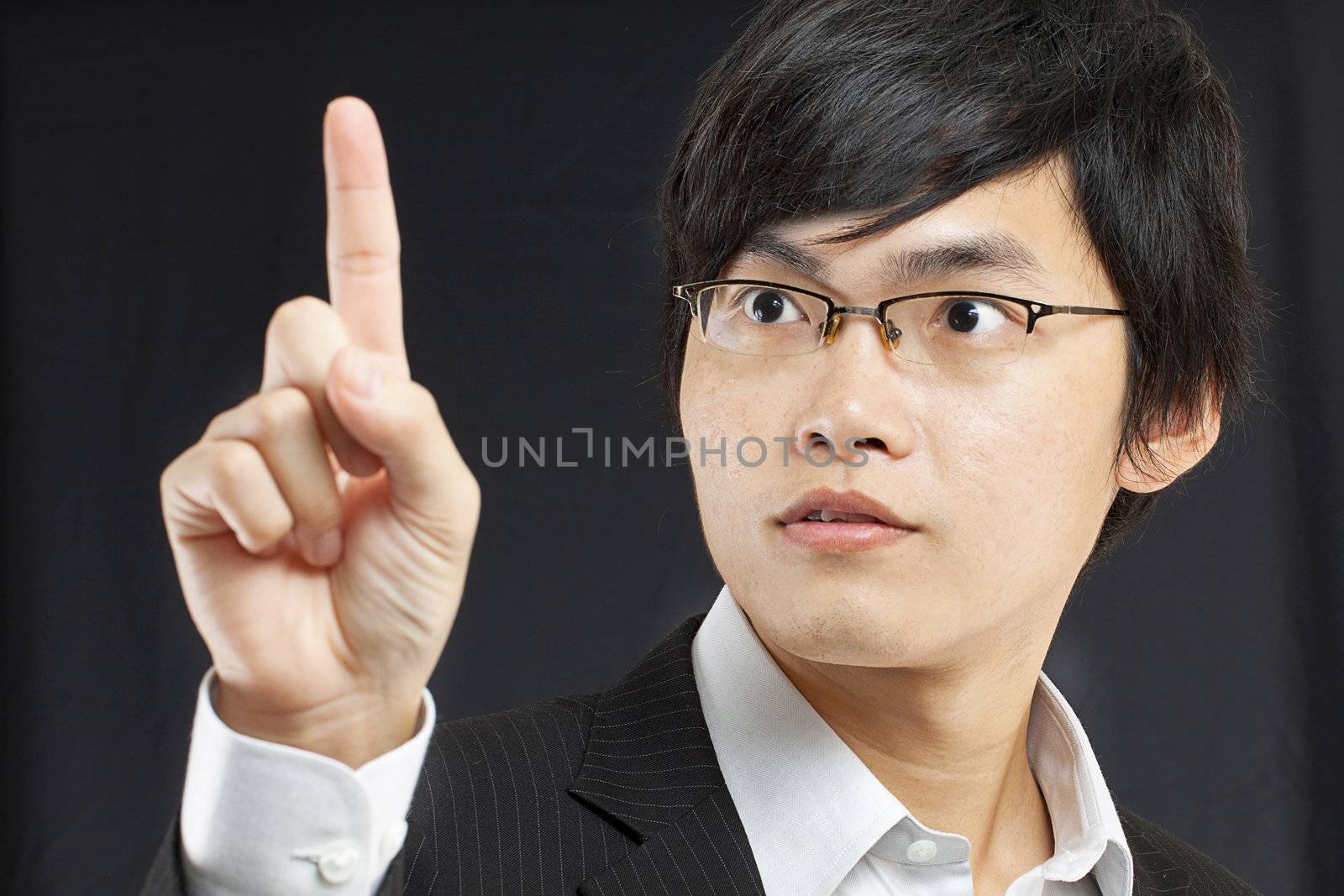 young business man in a suit pointing with his finger by cozyta