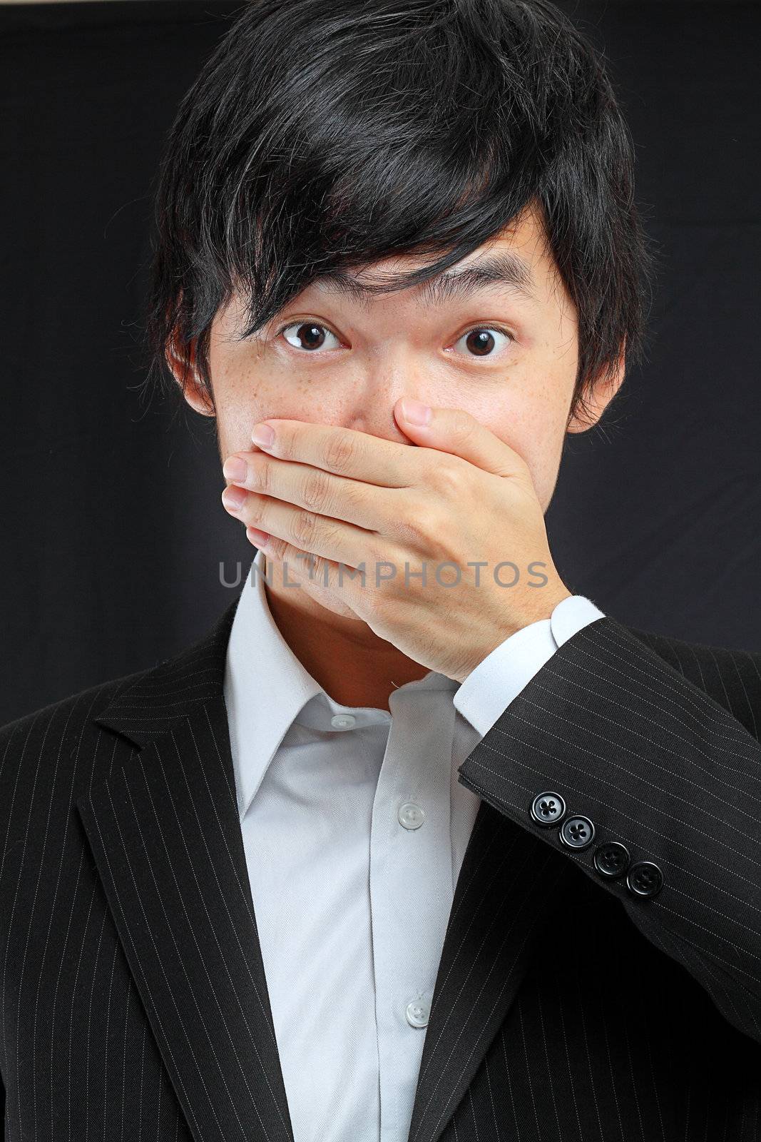 scared adult man with hand covering mouth  by cozyta