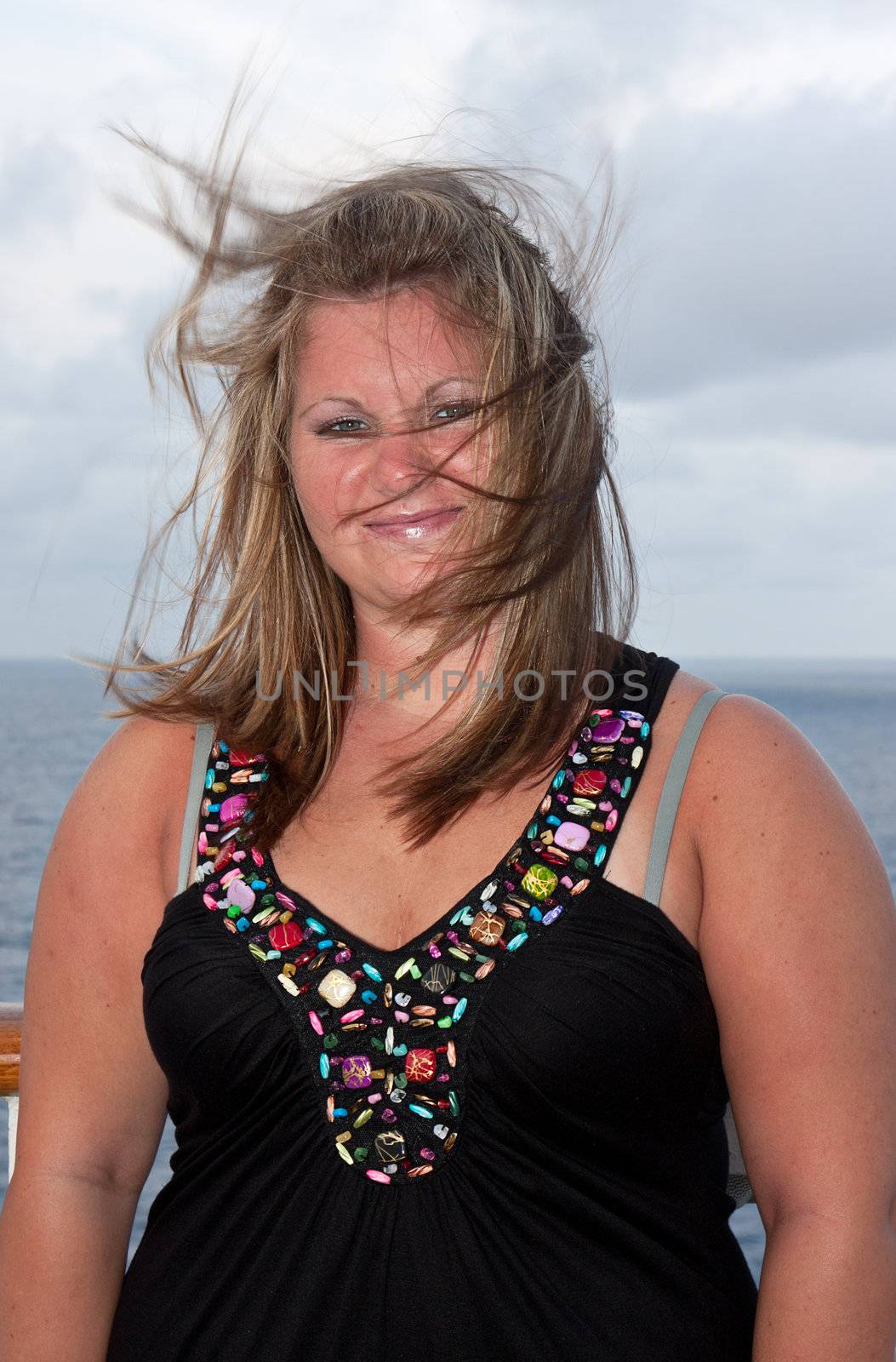 Portrait of a young woman on a cruise ship with hair blowing in the wind