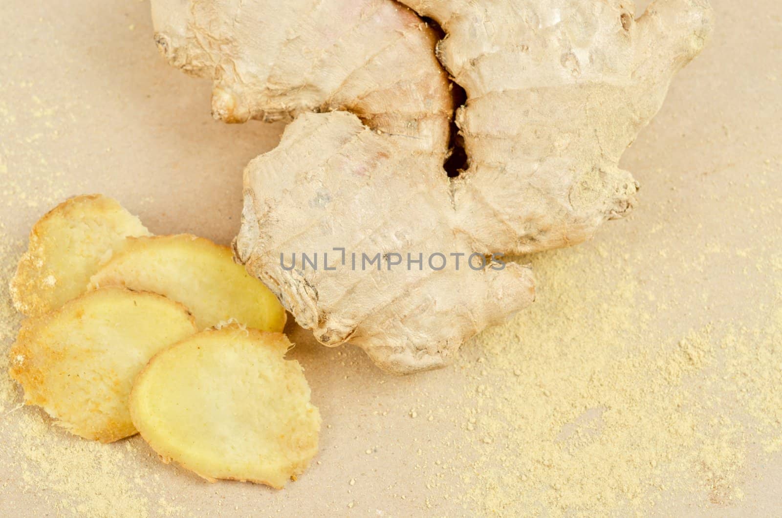 Fresh, dried and powdered ginger at brown background