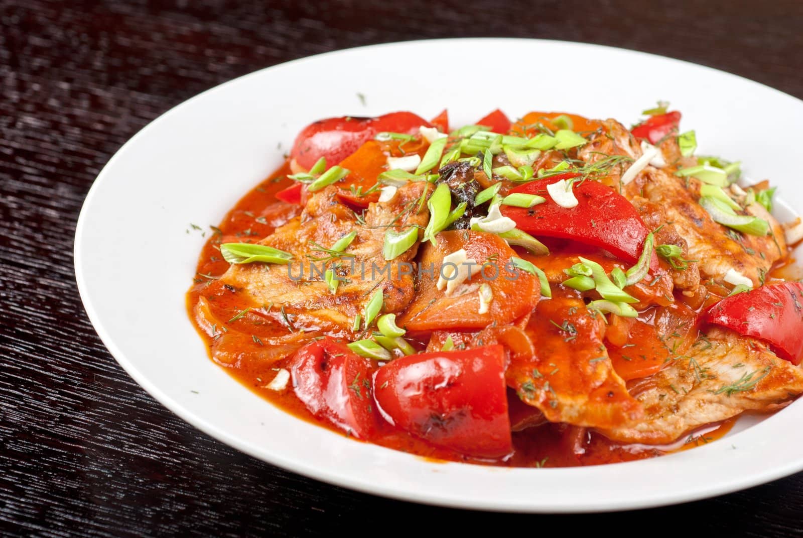 pork meat with tomato, pepper, prunes, garlic and green onion