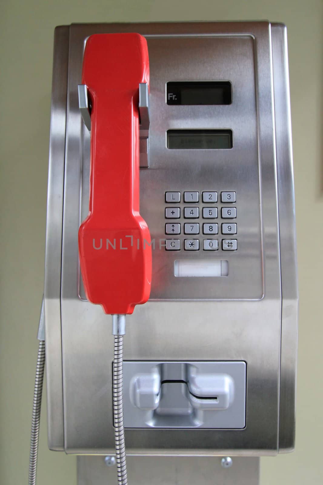 Close up of a grey and red public phone
