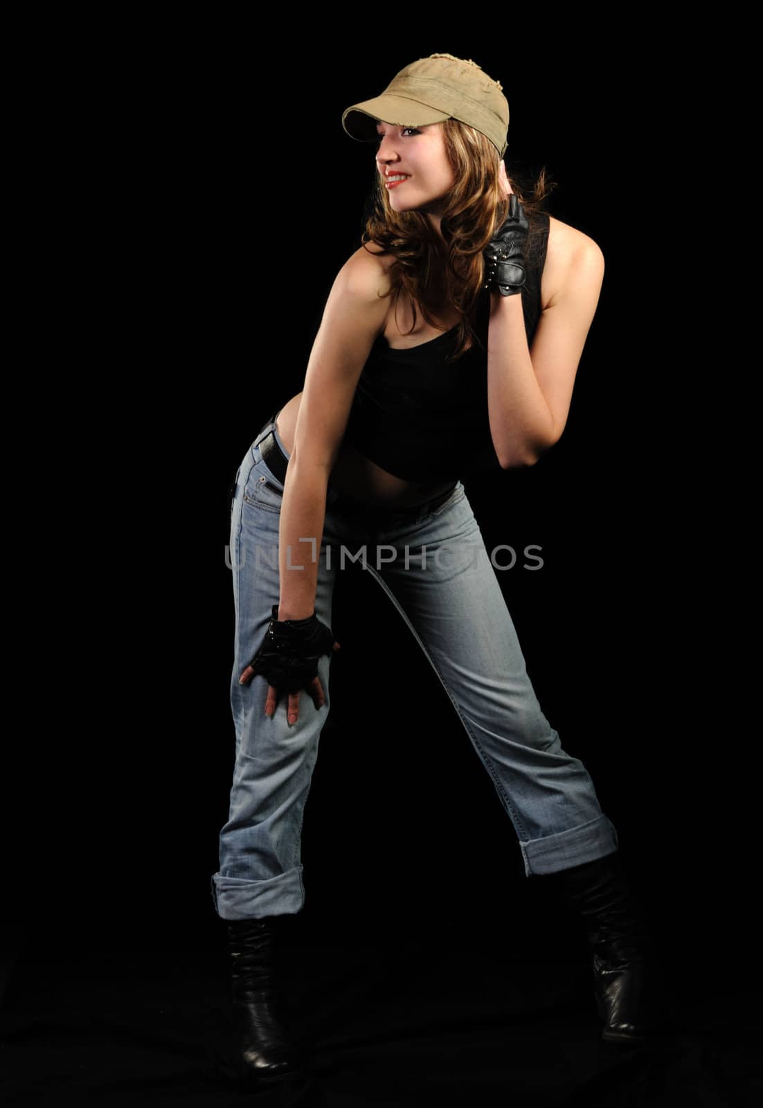 The woman in jeans and a stylish cap on a black background