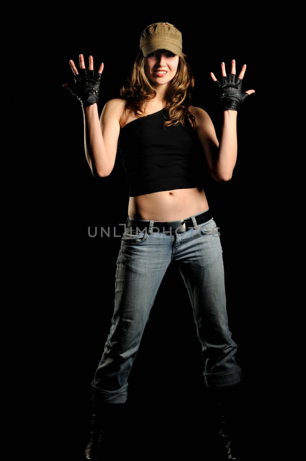 The woman in jeans and a stylish cap on a black background