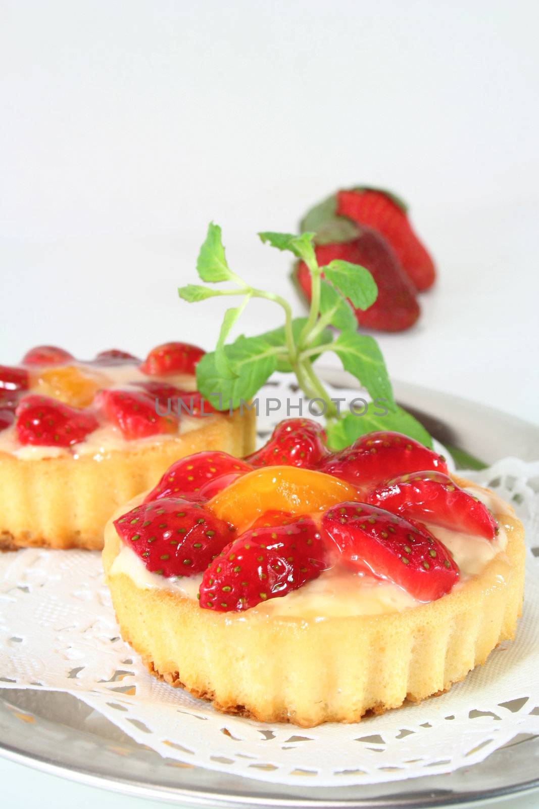 Strawberry tarts with mint on a silver platter