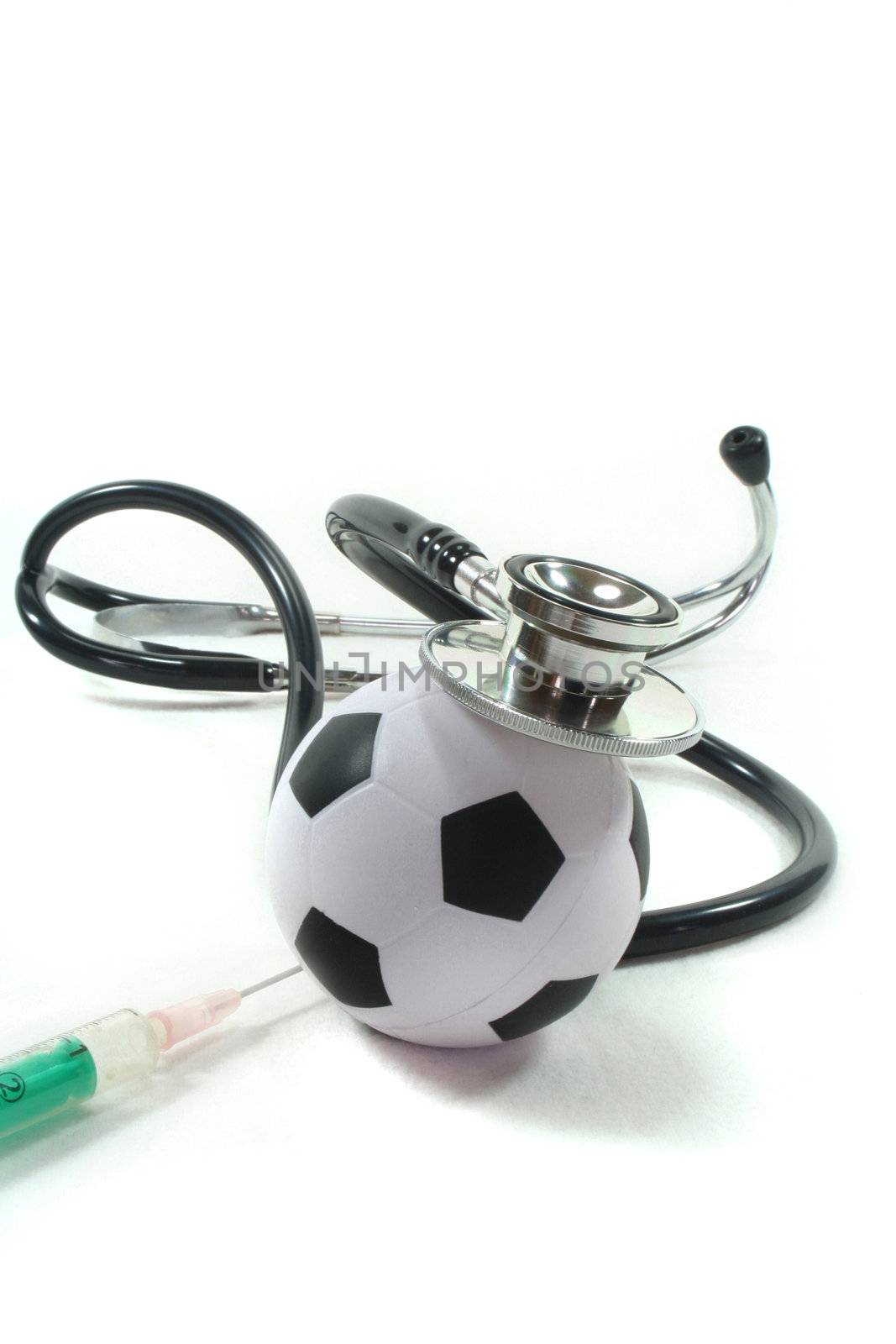 Stethoscope with football and syringe on a white background