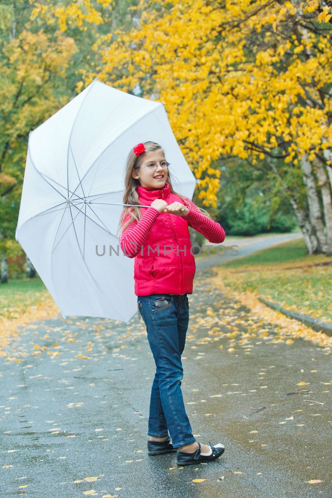 Cute girl with white umbrella walking in the autumn park