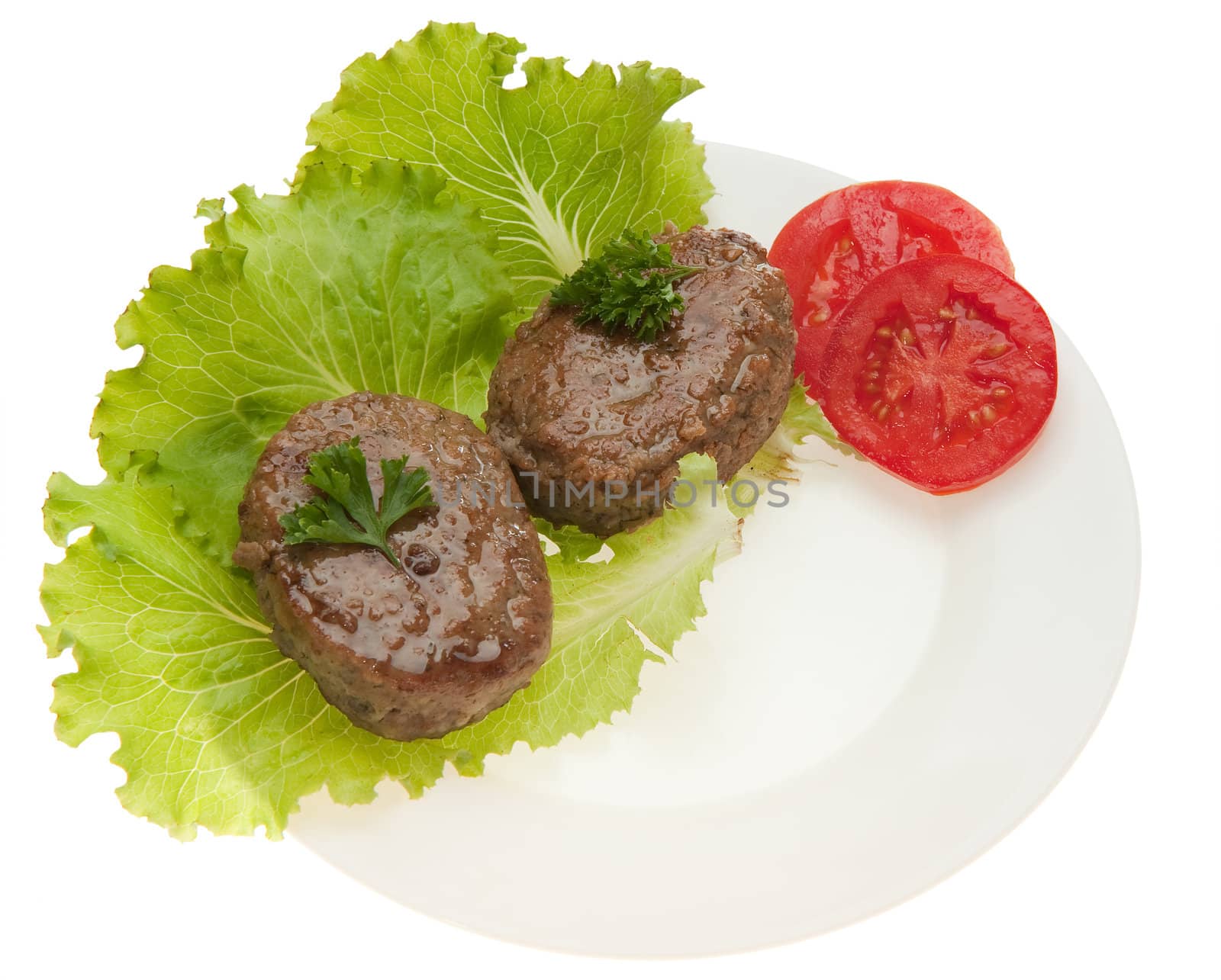 Cutlets with vegetables on a plate. It is isolated on a white background