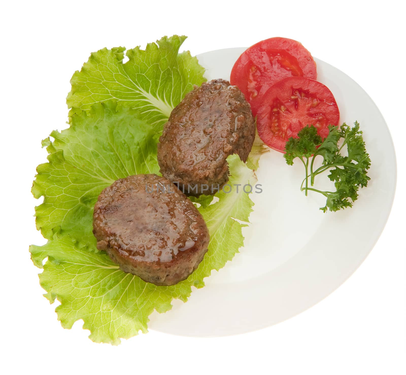 Cutlets with vegetables on a plate. It is isolated on a white background