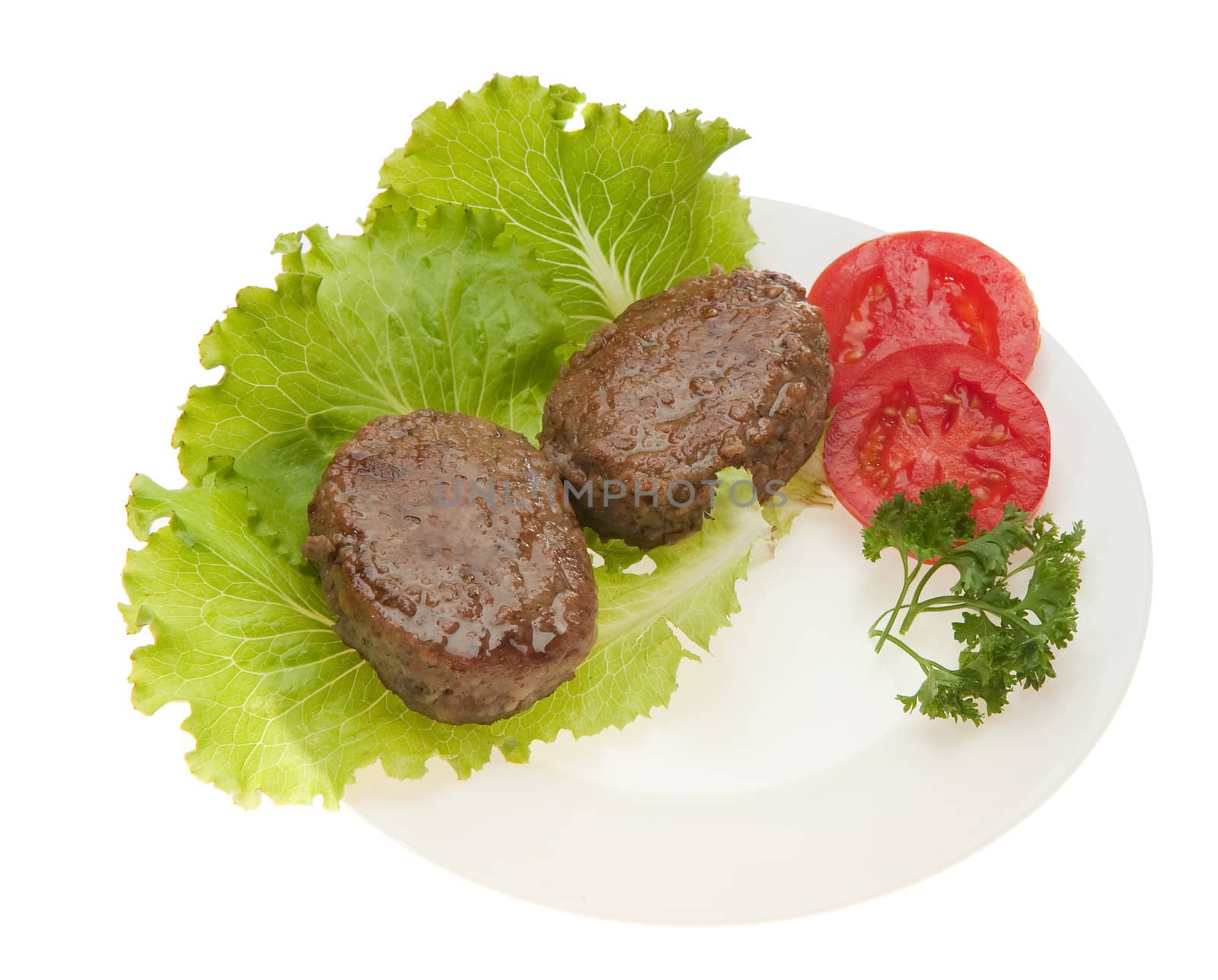 Cutlets with vegetables on a plate. It is isolated on a white background