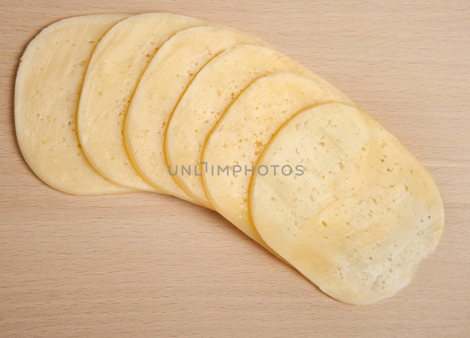 Cutting of cheese on a board on cutting of products. Studio shooting.