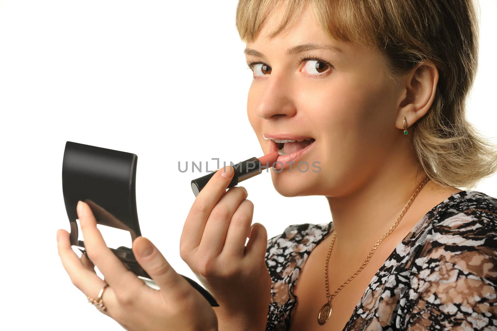 The young girl does a make-up. Paints lips