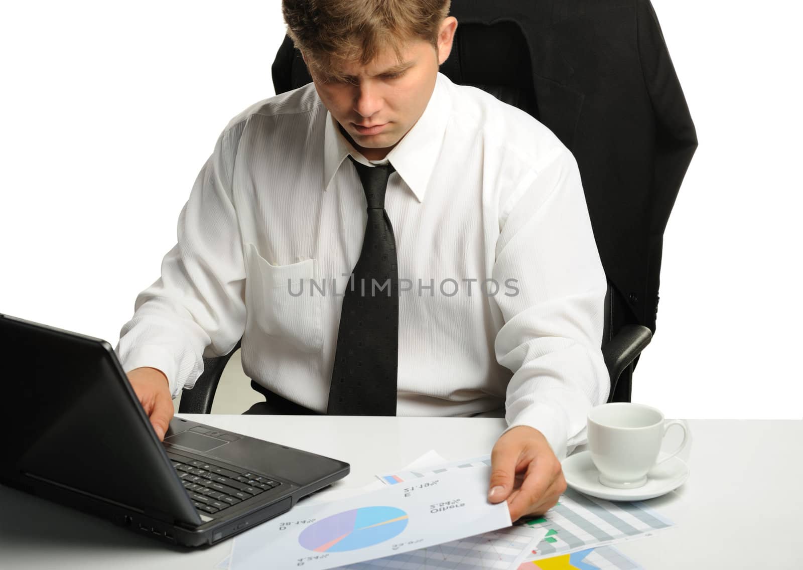 The young businessman on a workplace. It is isolated on a white background
