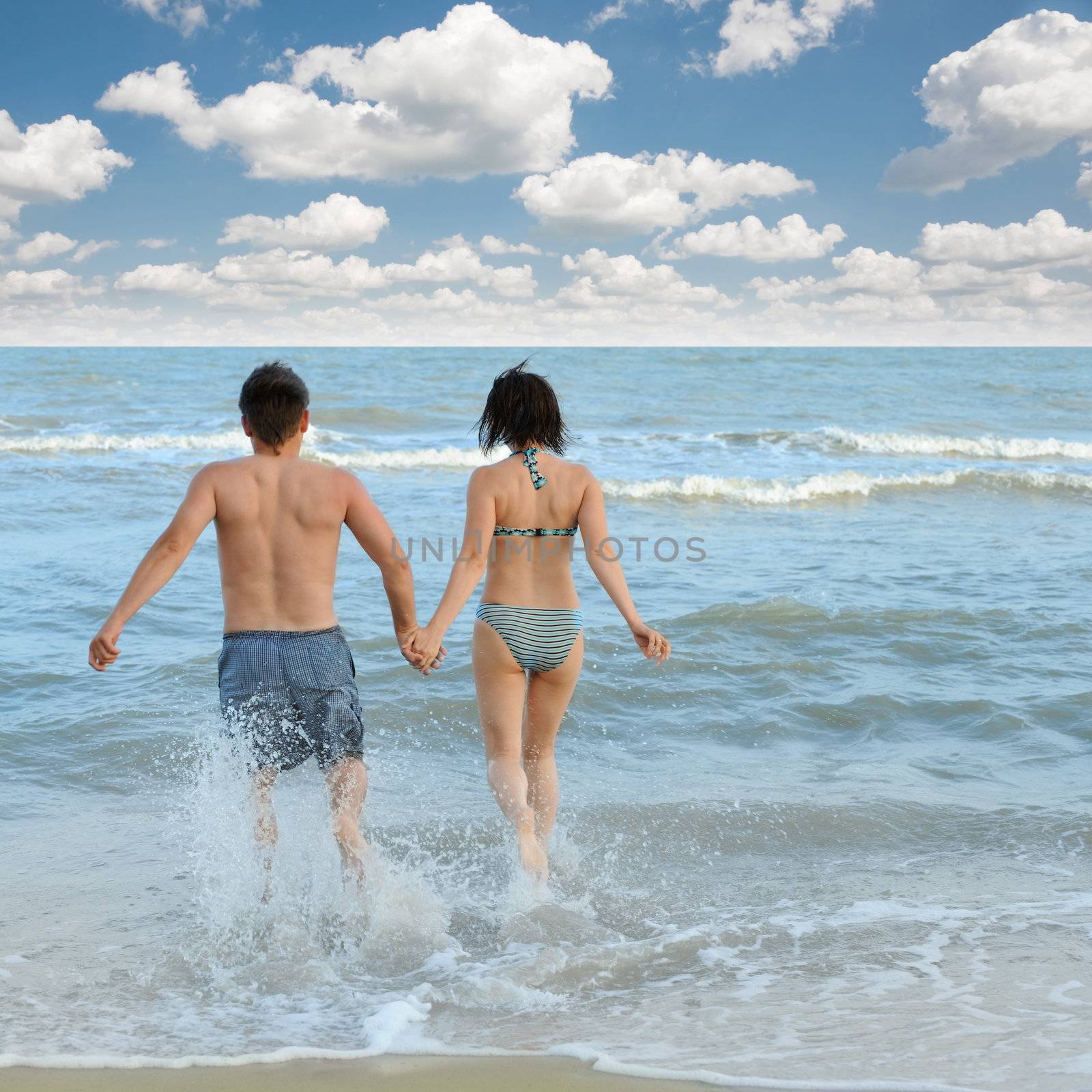 Pair on seacoast. The enamoured guy and the girl walking on coast