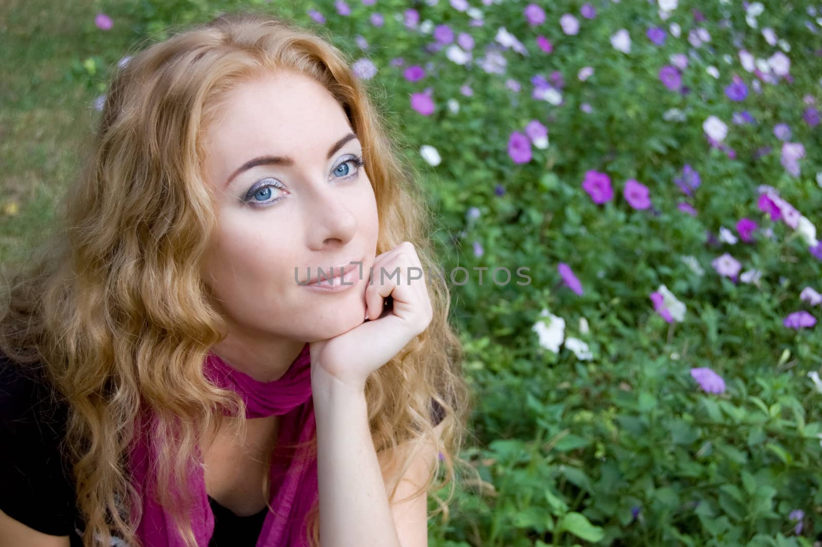 Red-headed woman among violet flowers in park