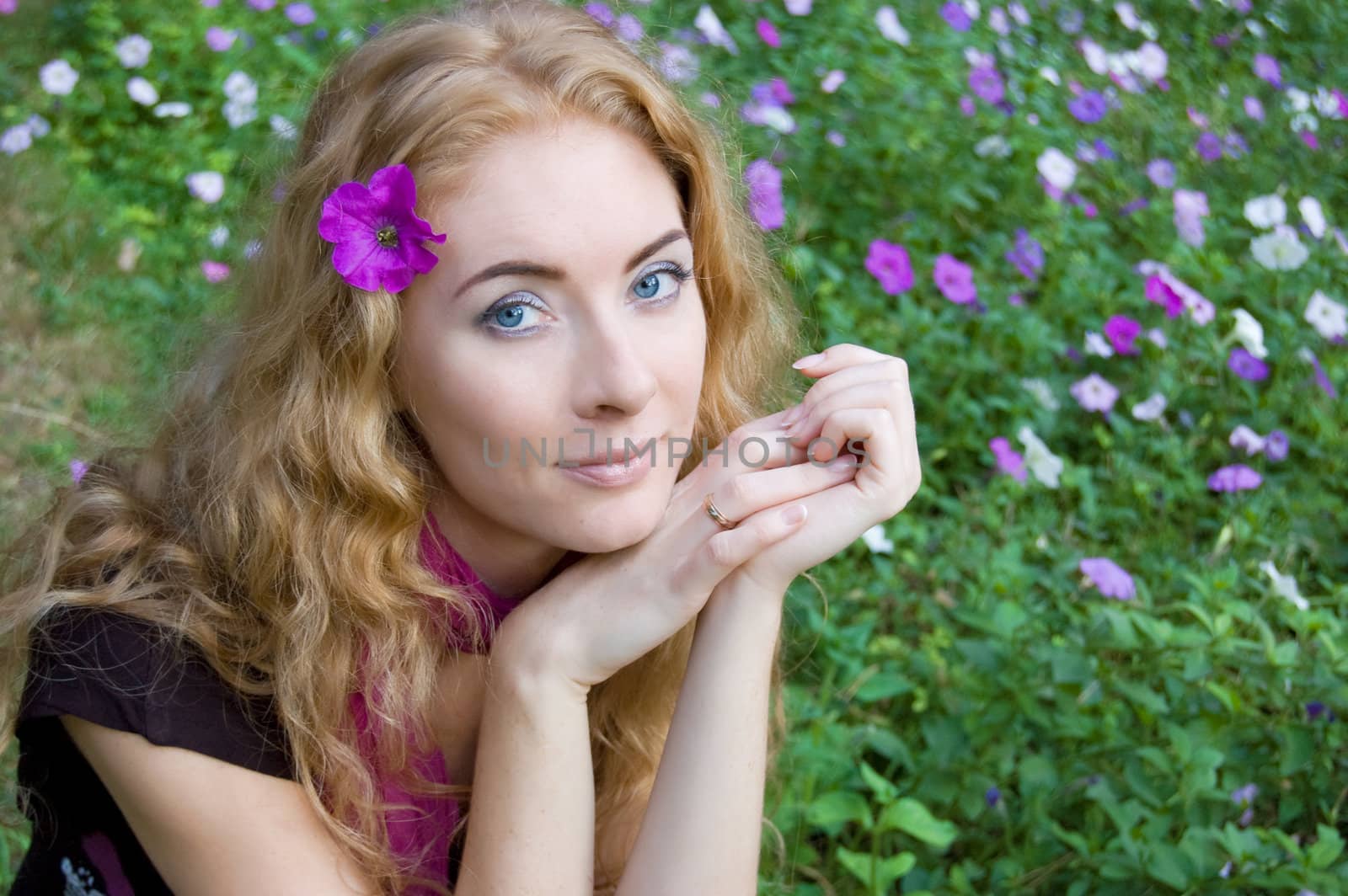 Red-headed woman among violet flowers in park