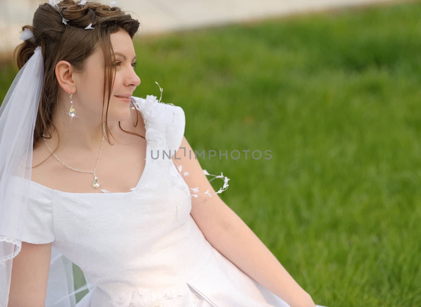 The bride on a lawn. The young girl in a wedding dress.