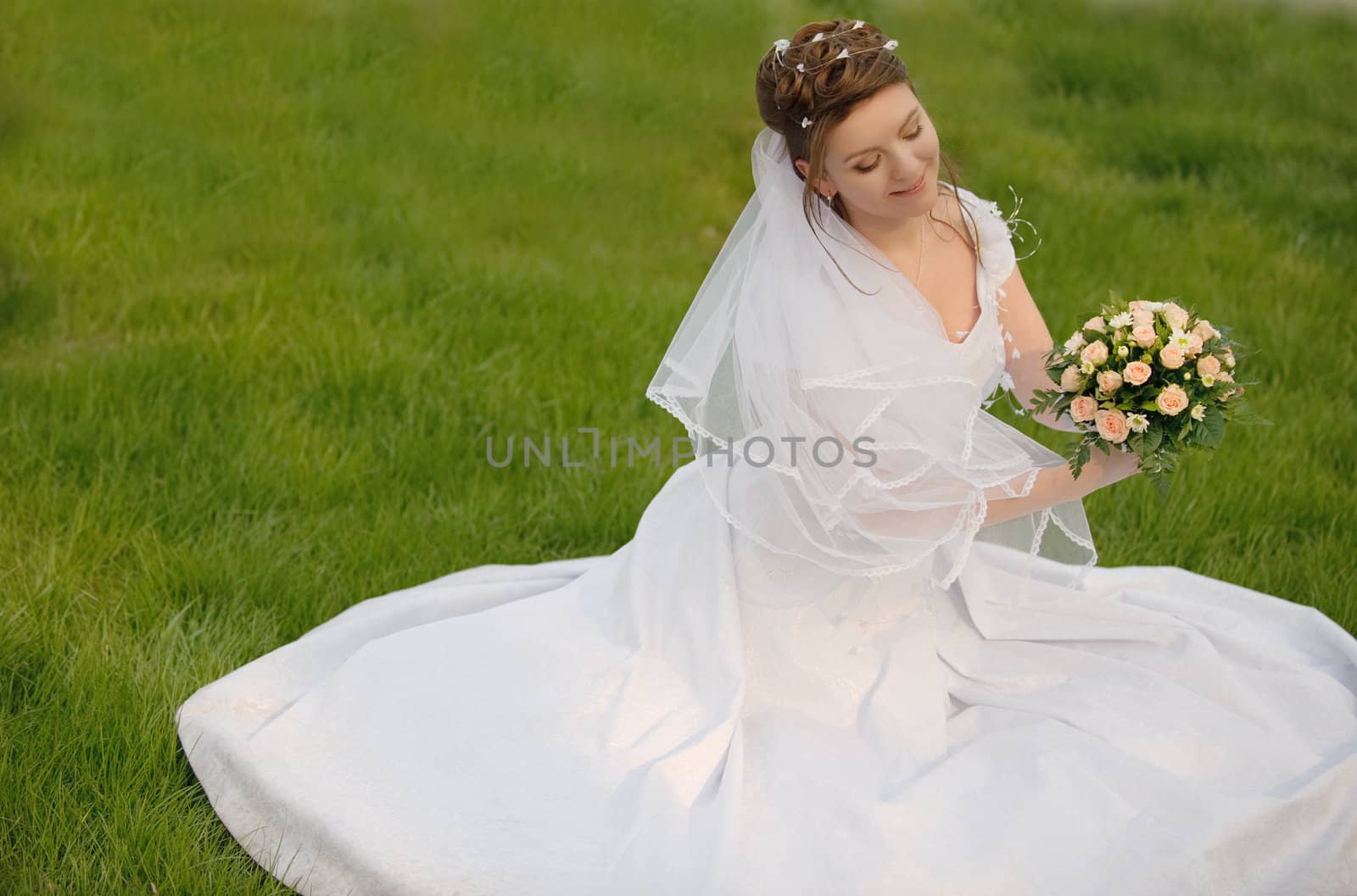 The bride on a lawn. The young girl in a wedding dress.