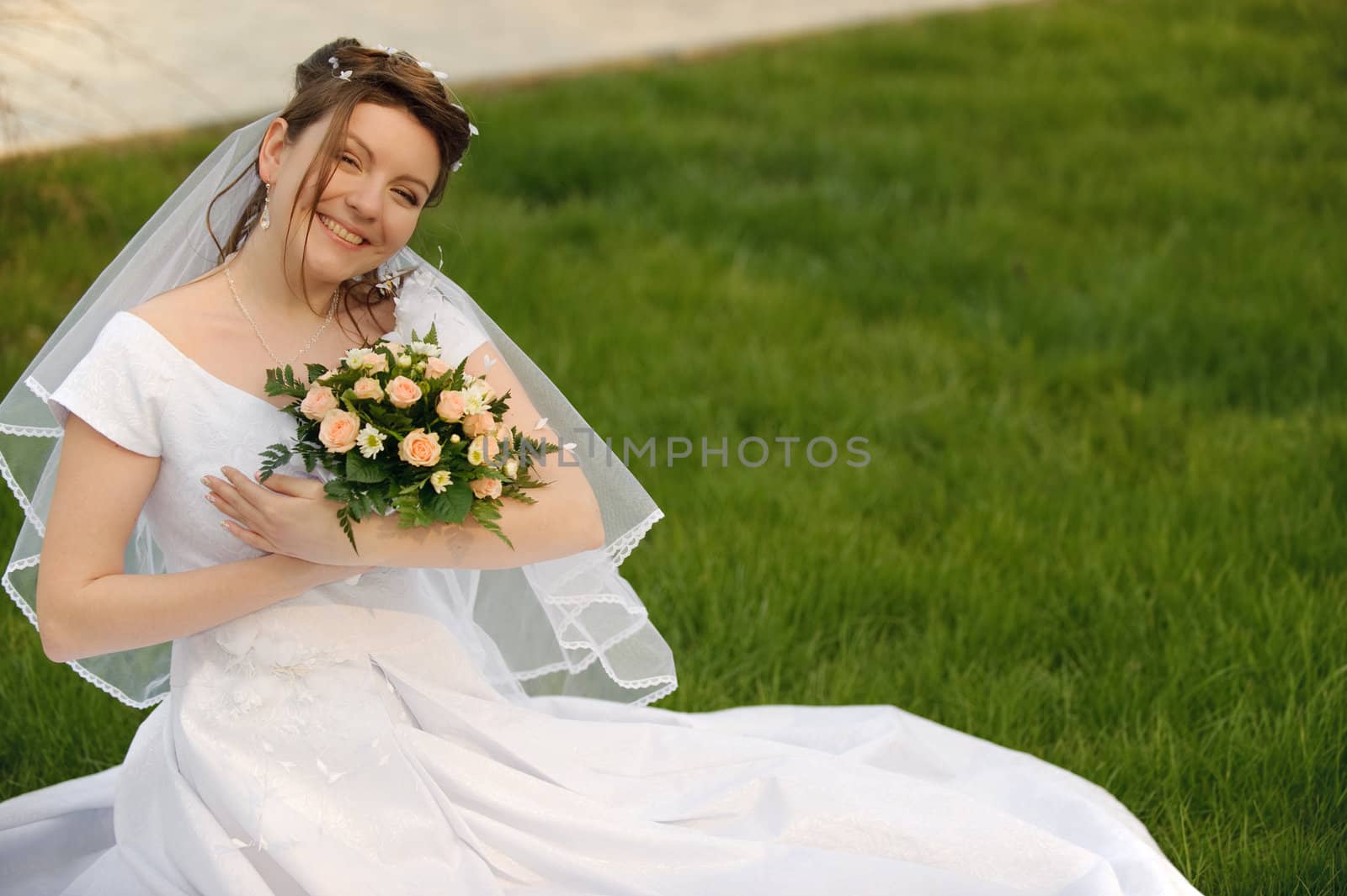 The bride on a lawn. The young girl in a wedding dress.