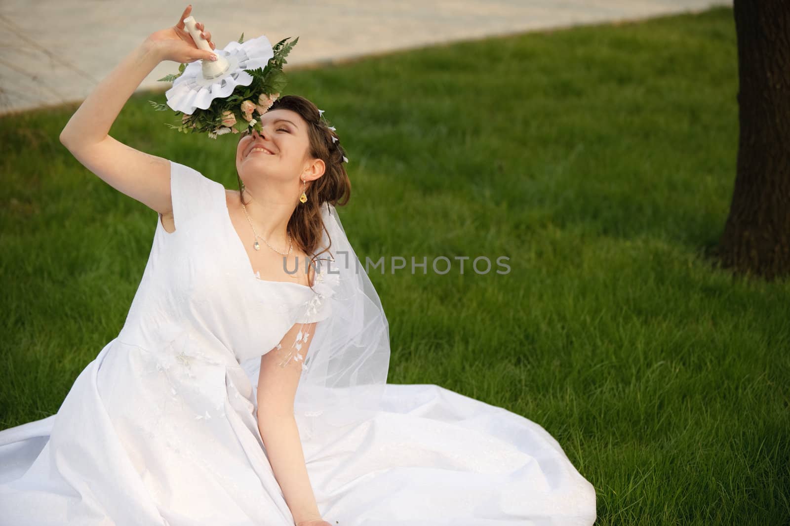 The bride on a lawn. The young girl in a wedding dress.