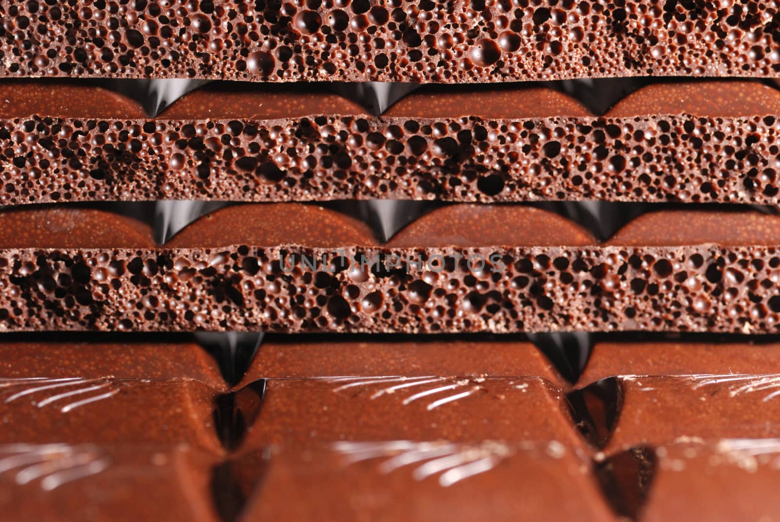 Chocolate. The broken tile of porous black chocolate